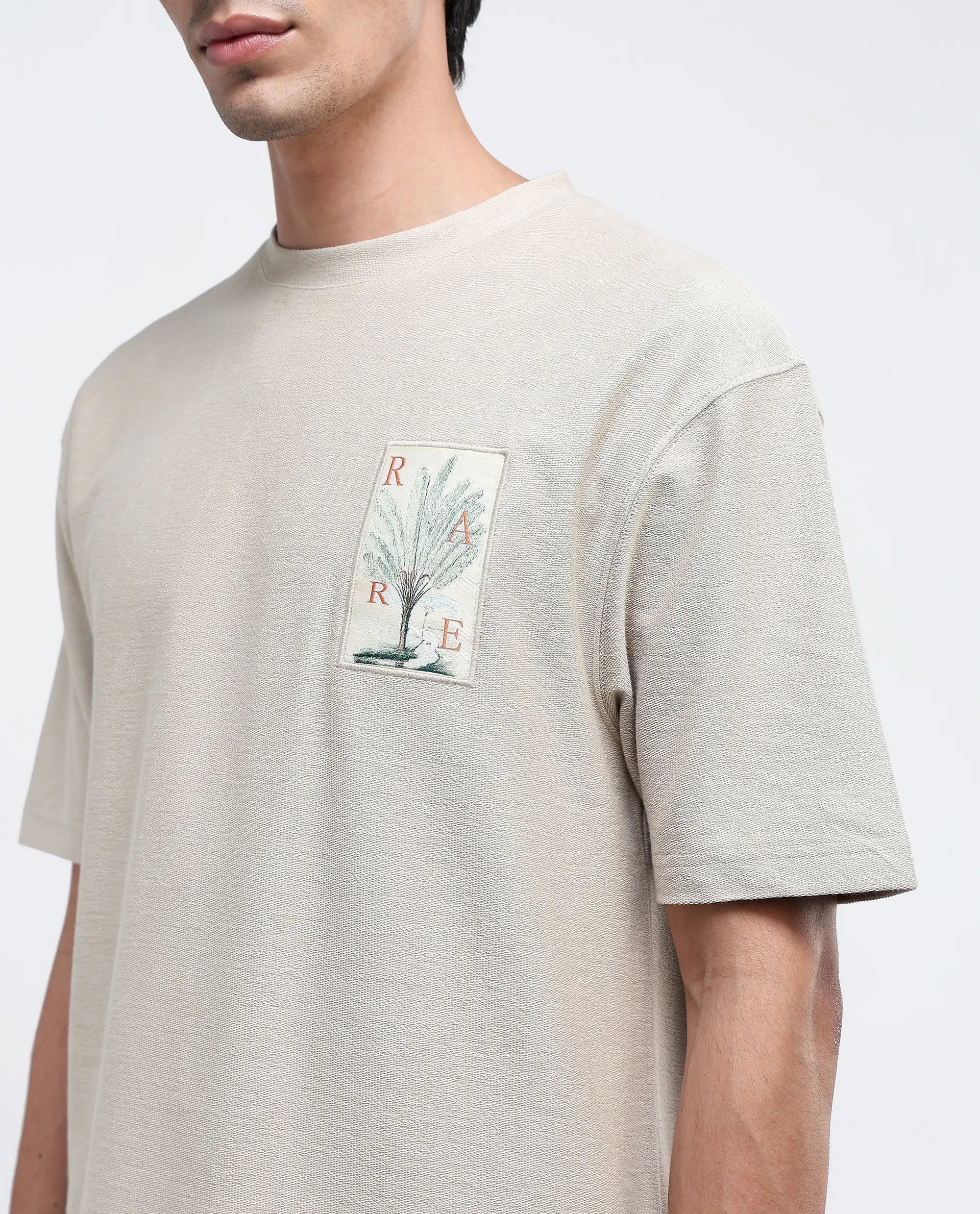 Rare Rabbit Men Loopet-1 Beige Cotton Lycra Fabric Half Sleeves Floral Print Pocket Detailing Oversized Fit Solid T-Shirt