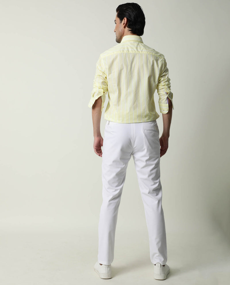 Premium Photo  A woman in a yellow shirt and white pants stands in front  of a white background