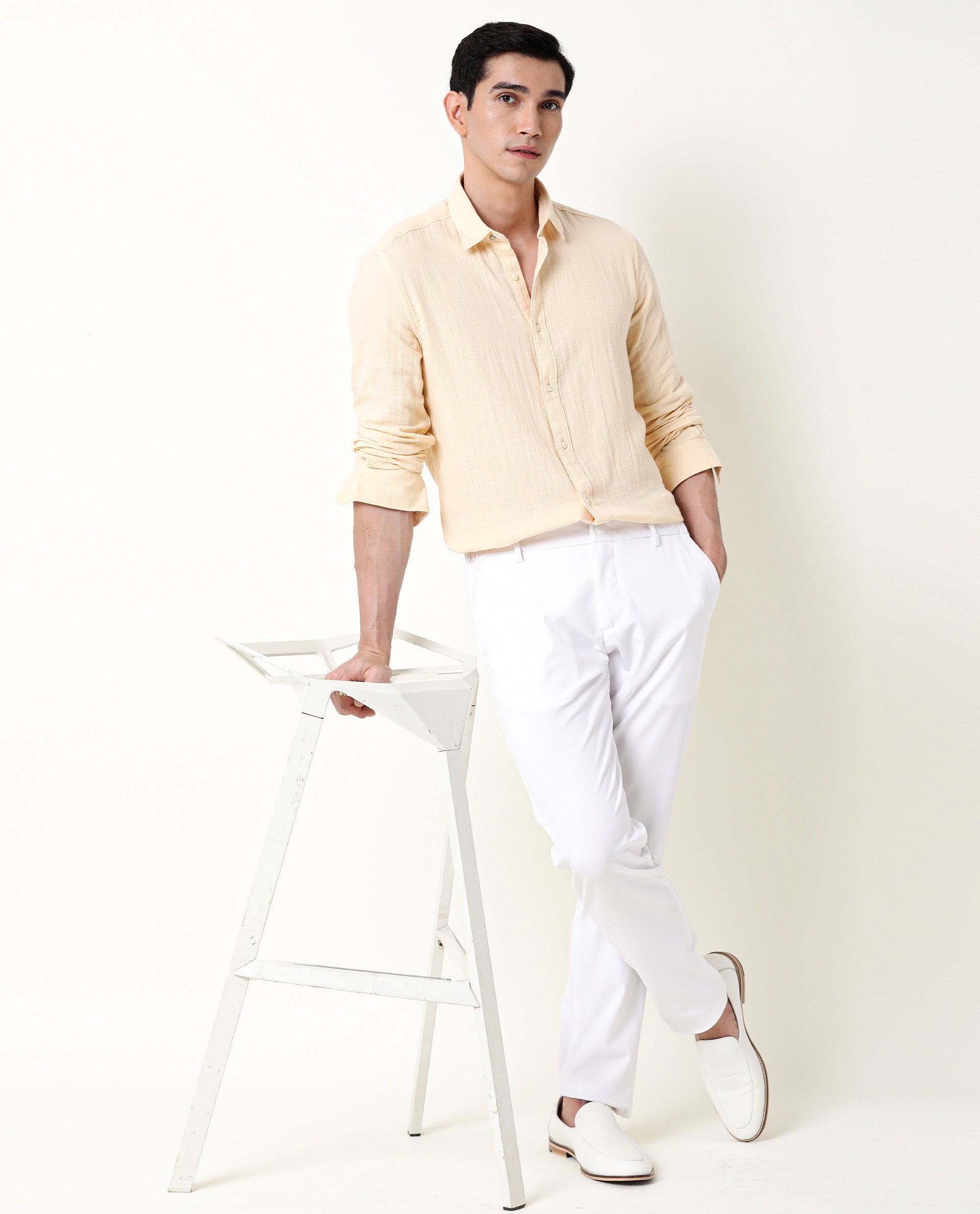 A Young Attractive Fellow In A White Shirt And Beige Pants Looks In The  Distance On A Light Blurred Background Stock Photo Picture and Royalty  Free Image Image 83948926